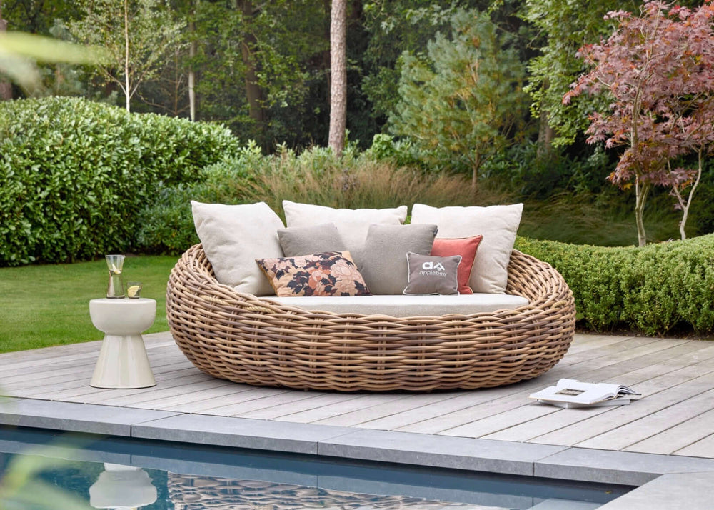 Apple Bee Cocoon loungeset met comfortabel ligbed en kussens in een serene tuinomgeving.