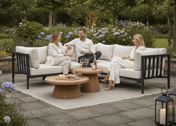Drie vrienden in een tuin, zittend op de Belito Daan Hoek Loungeset Aluminium All-Weather Chaise Longue - Rechts Lang.