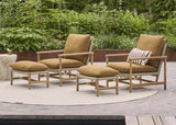 Twee Apple Bee Jamila loungestoelen met hockers in teak en amber op terras
